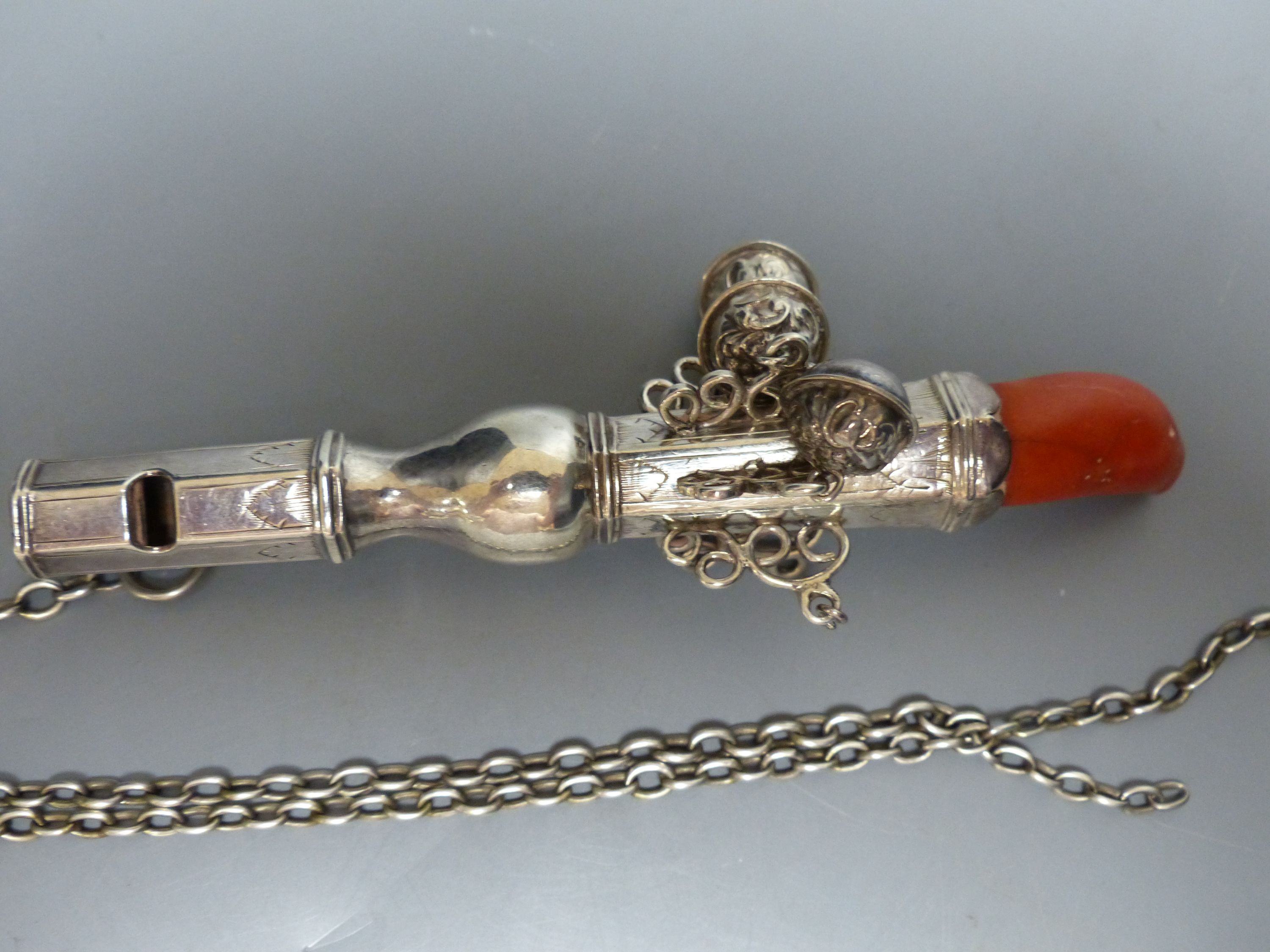 A 19th century? white metal child's rattle with coral teether and seven bells (2 detached) unmarked, 13cm,